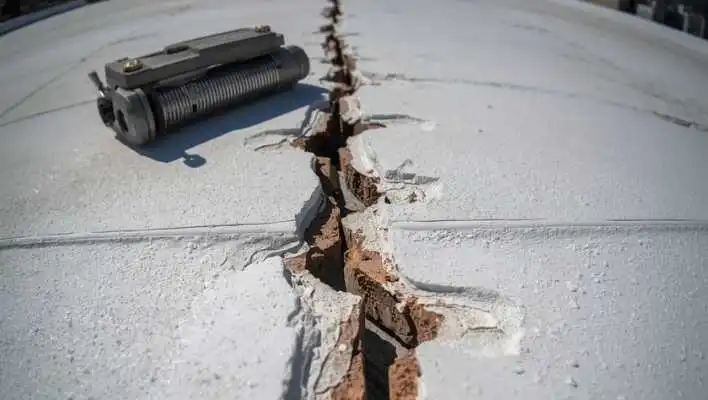 Flat roof membrane delamination and seam damage showing structural risk for commercial properties.